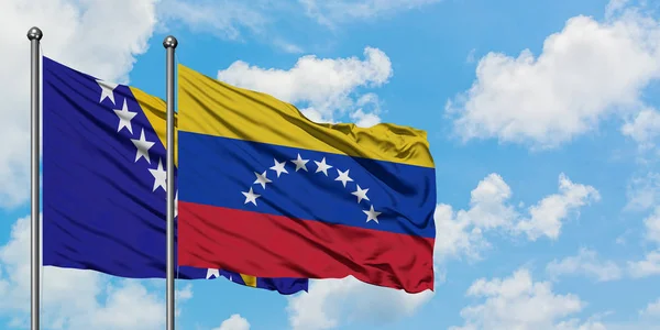 Bandera de Bosnia Herzegovina y Venezuela ondeando en el viento contra el cielo azul nublado blanco juntos. Concepto diplomático, relaciones internacionales . — Foto de Stock