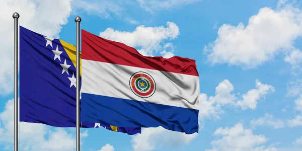 Bósnia-Herzegovina e Paraguai acenando com o vento contra o céu azul nublado branco juntos. Conceito de diplomacia, relações internacionais . — Fotografia de Stock