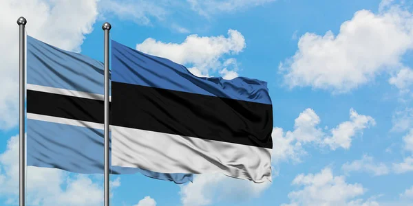 보츠와나와 에스토니아 국기가 함께 하얀 흐린 푸른 하늘에 바람을 흔들고. 외교 개념, 국제 관계. — 스톡 사진