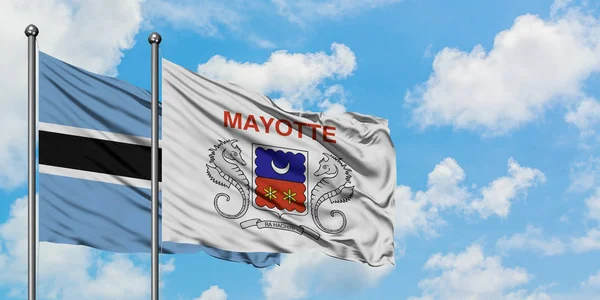 Bandera de Botswana y Mayotte ondeando en el viento contra el cielo azul nublado blanco juntos. Concepto diplomático, relaciones internacionales . —  Fotos de Stock