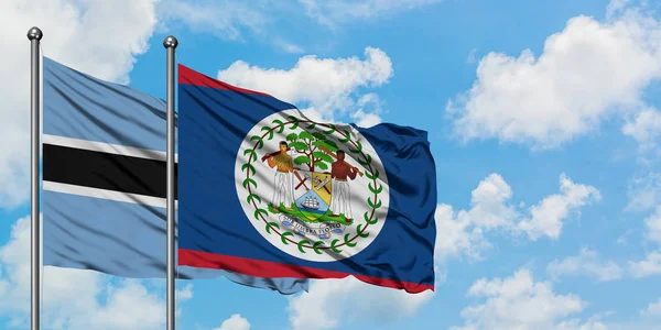 Bandera de Botswana y Belice ondeando en el viento contra el cielo azul nublado blanco juntos. Concepto diplomático, relaciones internacionales . — Foto de Stock