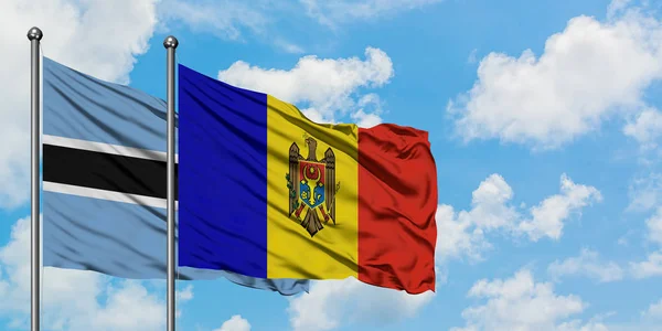 Bandera de Botswana y Moldavia ondeando en el viento contra el cielo azul nublado blanco juntos. Concepto diplomático, relaciones internacionales . — Foto de Stock