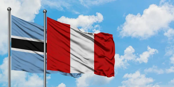 Bandera de Botswana y Perú ondeando en el viento contra el cielo azul nublado blanco juntos. Concepto diplomático, relaciones internacionales . —  Fotos de Stock