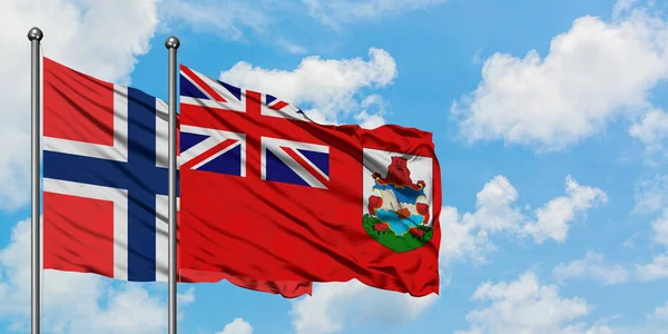 Islas Bouvet y la bandera de las Bermudas ondeando en el viento contra el cielo azul nublado blanco juntos. Concepto diplomático, relaciones internacionales . —  Fotos de Stock