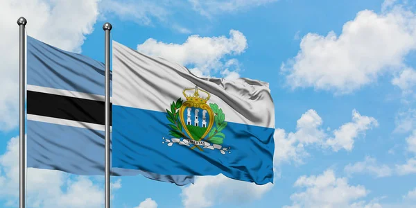 Ботсвана і Сан-Марино прапора розмахуючи в вітру проти білого хмарного синього неба разом. Концепція дипломатії, міжнародні відносини. — стокове фото
