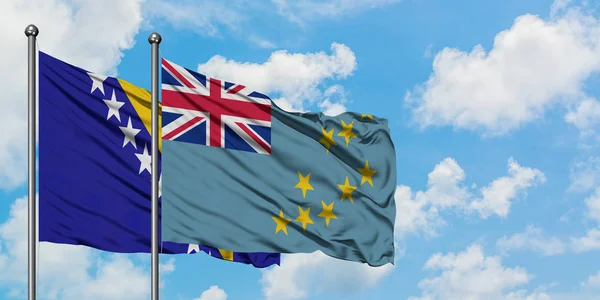 Bandera de Bosnia Herzegovina y Tuvalu ondeando en el viento contra el cielo azul nublado blanco juntos. Concepto diplomático, relaciones internacionales . — Foto de Stock