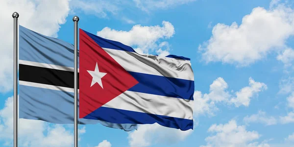 보츠와나와 쿠바 국기가 하얀 흐린 푸른 하늘을 배경으로 바람에 흔들리고 있습니다. 외교 개념, 국제 관계. — 스톡 사진