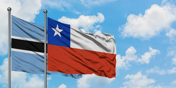 Bandera de Botswana y Chile ondeando en el viento contra el cielo azul nublado blanco juntos. Concepto diplomático, relaciones internacionales . — Foto de Stock