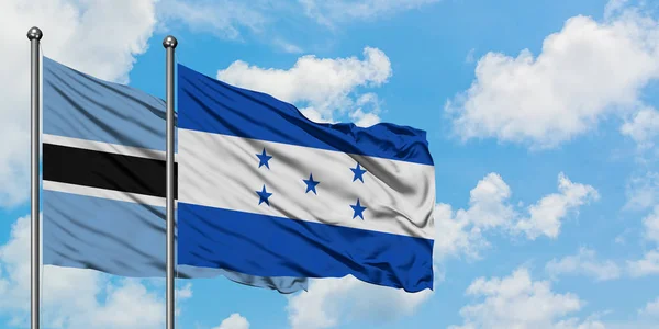 Ботсвана і Гондурас прапор розмахував вітром проти білого хмарного синього неба разом. Концепція дипломатії, міжнародні відносини. — стокове фото
