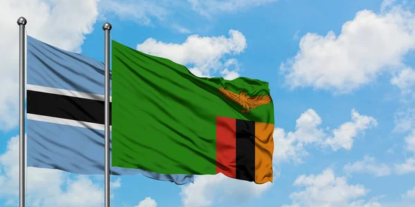 Botswana and Zambia flag waving in the wind against white cloudy blue sky together. Diplomacy concept, international relations. — Stock Photo, Image