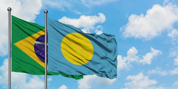 Bandeira do Brasil e Palau agitando no vento contra o céu azul nublado branco juntos. Conceito de diplomacia, relações internacionais . — Fotografia de Stock