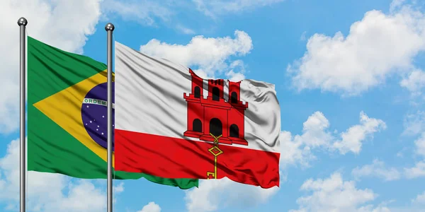 Бразилия и флаг Гибралтара вместе машут ветром против белого облачно-синего неба. Концепция дипломатии, международные отношения . — стоковое фото