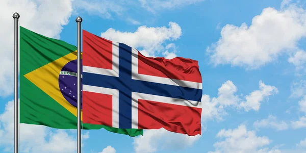 Bandera de Brasil y Noruega ondeando en el viento contra el cielo azul nublado blanco juntos. Concepto diplomático, relaciones internacionales . — Foto de Stock