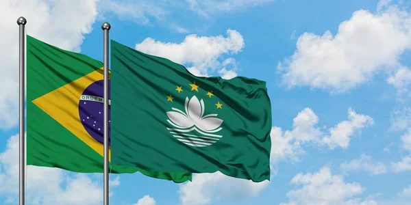 Brazil and Macao flag waving in the wind against white cloudy blue sky together. Diplomacy concept, international relations.