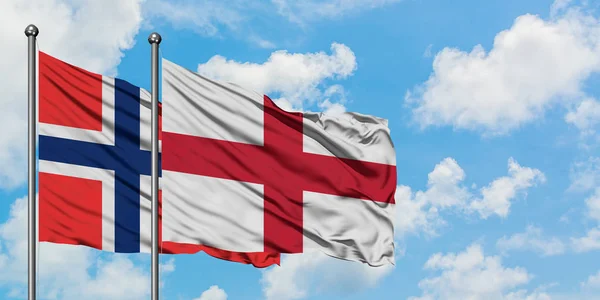 Islas Bouvet y bandera de Inglaterra ondeando en el viento contra el cielo azul nublado blanco juntos. Concepto diplomático, relaciones internacionales . —  Fotos de Stock