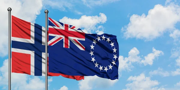 Bandera de las Islas Bouvet y las Islas Cook ondeando en el viento contra el cielo azul nublado blanco juntos. Concepto diplomático, relaciones internacionales . — Foto de Stock