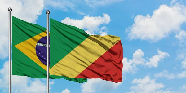Drapeau du Brésil et de la République du Congo agitant dans le vent contre le ciel bleu nuageux blanc ensemble. Concept de diplomatie, relations internationales . — Photo