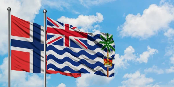 Bandera de las Islas Bouvet y del Territorio Británico del Océano Índico ondeando en el viento contra el cielo azul nublado blanco juntos. Concepto diplomático, relaciones internacionales . — Foto de Stock