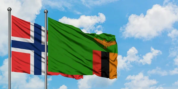 Bandera de las Islas Bouvet y Zambia ondeando en el viento contra el cielo azul nublado blanco juntos. Concepto diplomático, relaciones internacionales . — Foto de Stock