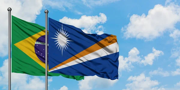 Brazílie a Marshallovy ostrovy vlají ve větru proti bíle zatažené modré obloze. Diplomacie, mezinárodní vztahy. — Stock fotografie