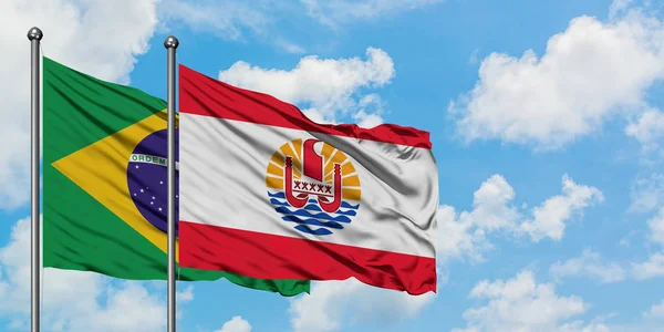 Brazil and French Polynesia flag waving in the wind against white cloudy blue sky together. Diplomacy concept, international relations. — Stock Photo, Image