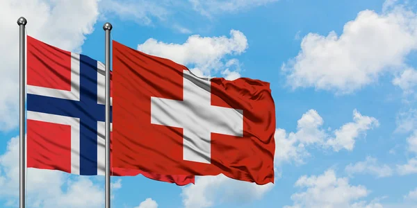 Bandera de las Islas Bouvet y Suiza ondeando en el viento contra el cielo azul nublado blanco juntos. Concepto diplomático, relaciones internacionales . —  Fotos de Stock