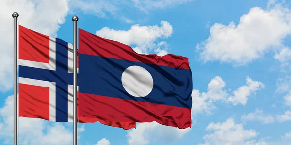 Bouvet Islands e la bandiera del Laos sventolano insieme nel vento contro il bianco cielo blu nuvoloso. Concetto di diplomazia, relazioni internazionali . — Foto Stock
