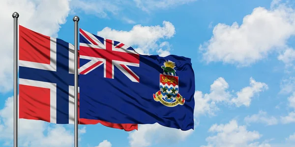 Bouveské ostrovy a Kajmanské ostrovy vlají ve větru proti bílé zatažené modré obloze dohromady. Diplomacie, mezinárodní vztahy. — Stock fotografie