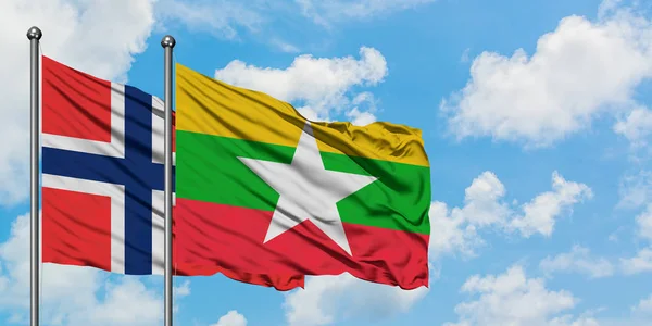 Bandera de las Islas Bouvet y Myanmar ondeando en el viento contra el cielo azul nublado blanco juntos. Concepto diplomático, relaciones internacionales . — Foto de Stock