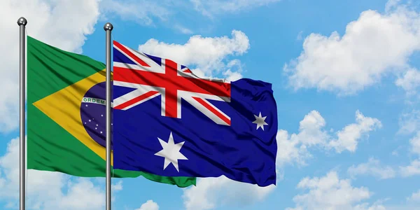 Bandera de Brasil e Islas Heard e Islas Mcdonald ondeando en el viento contra el cielo azul nublado blanco juntos. Concepto diplomático, relaciones internacionales . — Foto de Stock