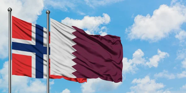 Bouvet öar och Qatar flagga vinka i vinden mot vit grumlig blå himmel tillsammans. Diplomatisk koncept, internationella relationer. — Stockfoto