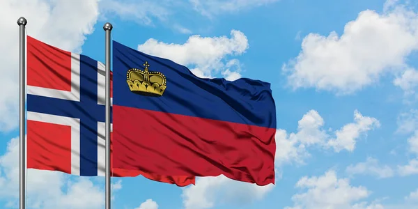 Drapeau des îles Bouvet et du Liechtenstein agitant dans le vent contre le ciel bleu nuageux blanc ensemble. Concept de diplomatie, relations internationales . — Photo