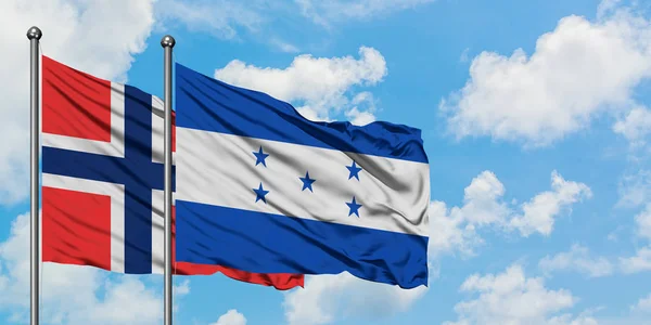 Bandera de las Islas Bouvet y Honduras ondeando en el viento contra el cielo azul nublado blanco juntos. Concepto diplomático, relaciones internacionales . — Foto de Stock