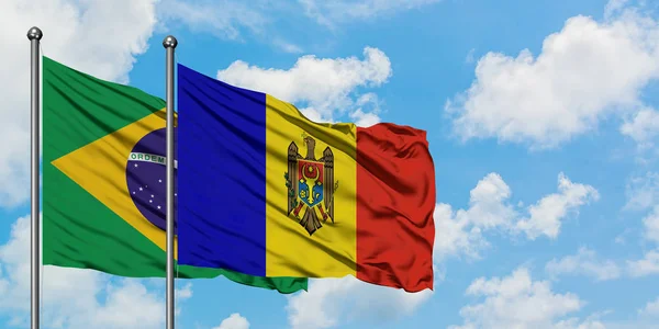 Bandera de Brasil y Moldavia ondeando en el viento contra el cielo azul nublado blanco juntos. Concepto diplomático, relaciones internacionales . —  Fotos de Stock