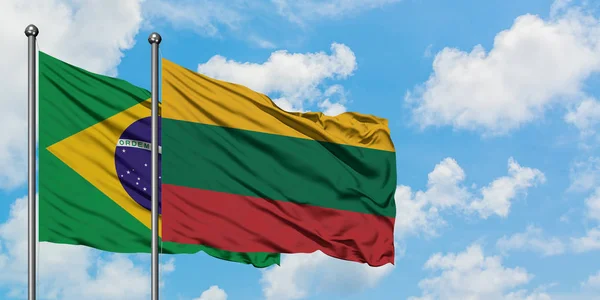 Brazílie a Litva vlají ve větru proti bíle zatažené modré obloze. Diplomacie, mezinárodní vztahy. — Stock fotografie