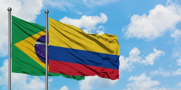 Brazil and Colombia flag waving in the wind against white cloudy blue sky together. Diplomacy concept, international relations. — Stock Photo, Image