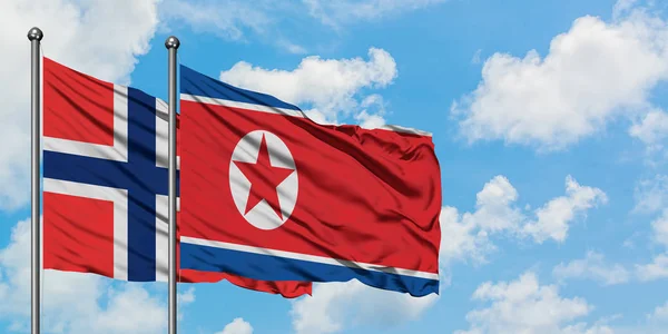 Bouvet Adaları ve Kuzey Kore bayrağı birlikte beyaz bulutlu mavi gökyüzüne karşı rüzgarsal sallayarak. Diplomasi kavramı, uluslararası ilişkiler. — Stok fotoğraf
