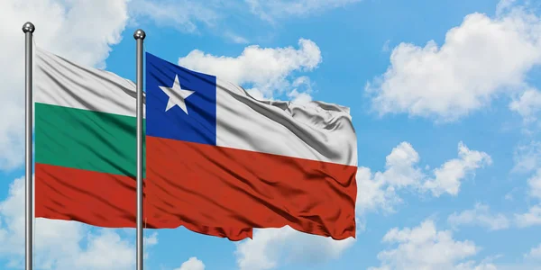 Bandera de Bulgaria y Chile ondeando en el viento contra el cielo azul nublado blanco juntos. Concepto diplomático, relaciones internacionales . — Foto de Stock