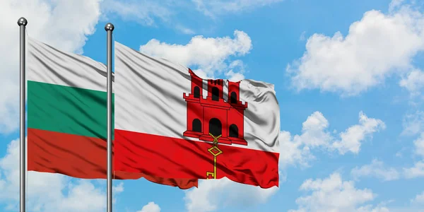 Bandera de Bulgaria y Gibraltar ondeando en el viento contra el cielo azul nublado blanco juntos. Concepto diplomático, relaciones internacionales . — Foto de Stock