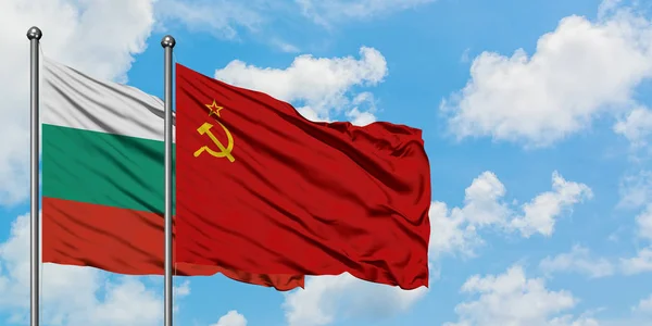 Bandera de Bulgaria y la Unión Soviética ondeando en el viento contra el cielo azul nublado blanco juntos. Concepto diplomático, relaciones internacionales . — Foto de Stock