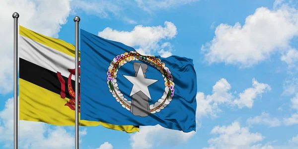 Bandeira de Brunei e Ilhas Marianas do Norte agitando no vento contra o céu azul nublado branco juntos. Conceito de diplomacia, relações internacionais . — Fotografia de Stock