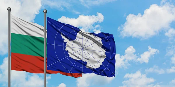 Bandera de Bulgaria y la Antártida ondeando en el viento contra el cielo azul nublado blanco juntos. Concepto diplomático, relaciones internacionales . — Foto de Stock