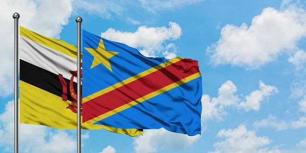 Bandera de Brunéi y Congo ondeando en el viento contra el cielo azul nublado blanco juntos. Concepto diplomático, relaciones internacionales . — Foto de Stock
