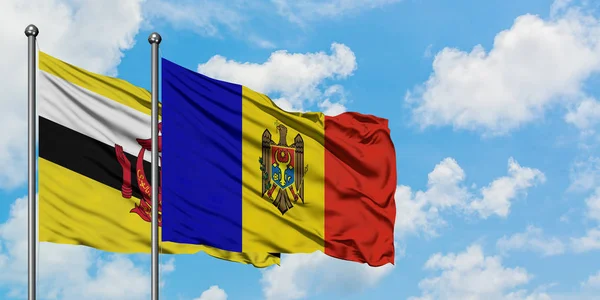 Bandera de Brunéi y Moldavia ondeando en el viento contra el cielo azul nublado blanco juntos. Concepto diplomático, relaciones internacionales . — Foto de Stock