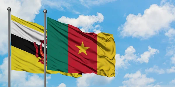 Bandera de Brunéi y Camerún ondeando en el viento contra el cielo azul nublado blanco juntos. Concepto diplomático, relaciones internacionales . — Foto de Stock