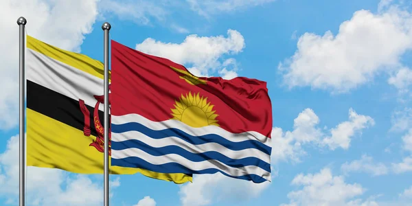 Bandera de Brunei y Kiribati ondeando en el viento contra el cielo azul nublado blanco juntos. Concepto diplomático, relaciones internacionales . — Foto de Stock