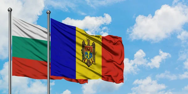 Bandera de Bulgaria y Moldavia ondeando en el viento contra el cielo azul nublado blanco juntos. Concepto diplomático, relaciones internacionales . — Foto de Stock