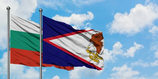Bandera de Bulgaria y Samoa Americana ondeando en el viento contra el cielo azul nublado blanco juntos. Concepto diplomático, relaciones internacionales . — Foto de Stock