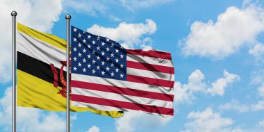 Brunei ve Amerika Birleşik Devletleri bayrağı birlikte beyaz bulutlu mavi gökyüzüne karşı rüzgarda sallayarak. Diplomasi kavramı, uluslararası ilişkiler.