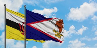 Brunei ve Amerikan Samoası bayrağı birlikte beyaz bulutlu mavi gökyüzüne karşı rüzgarda sallayarak. Diplomasi kavramı, uluslararası ilişkiler.